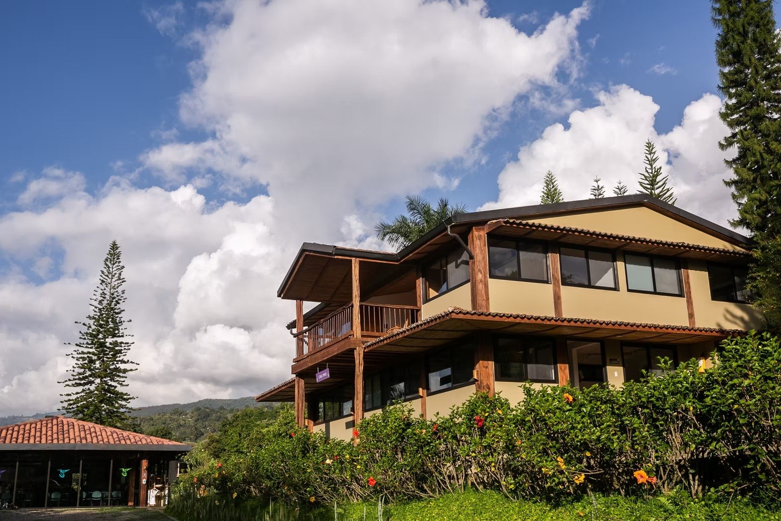 Casa Sumapaz main house exterior with blue sky and hibiscus garden