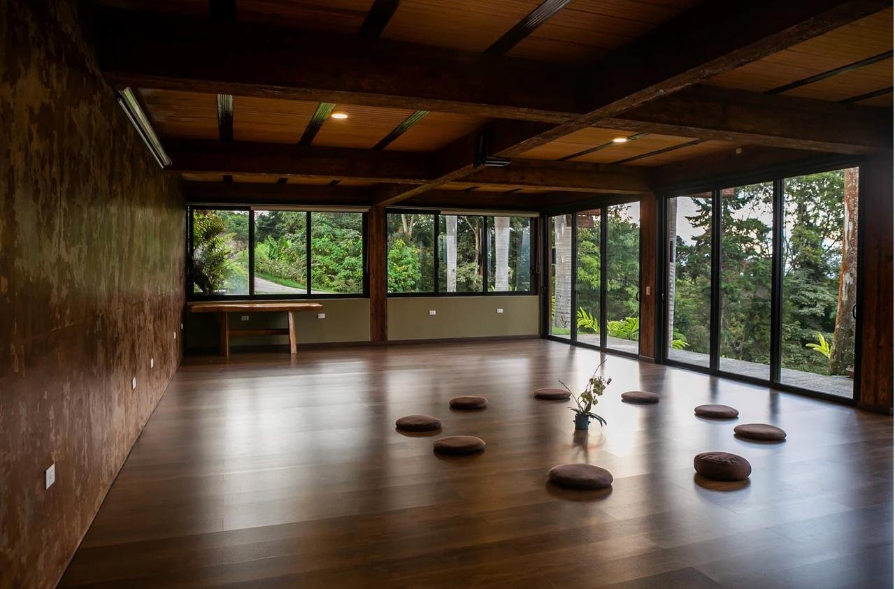 Open yoga pavilion with wooden floor and panoramic mountain views
