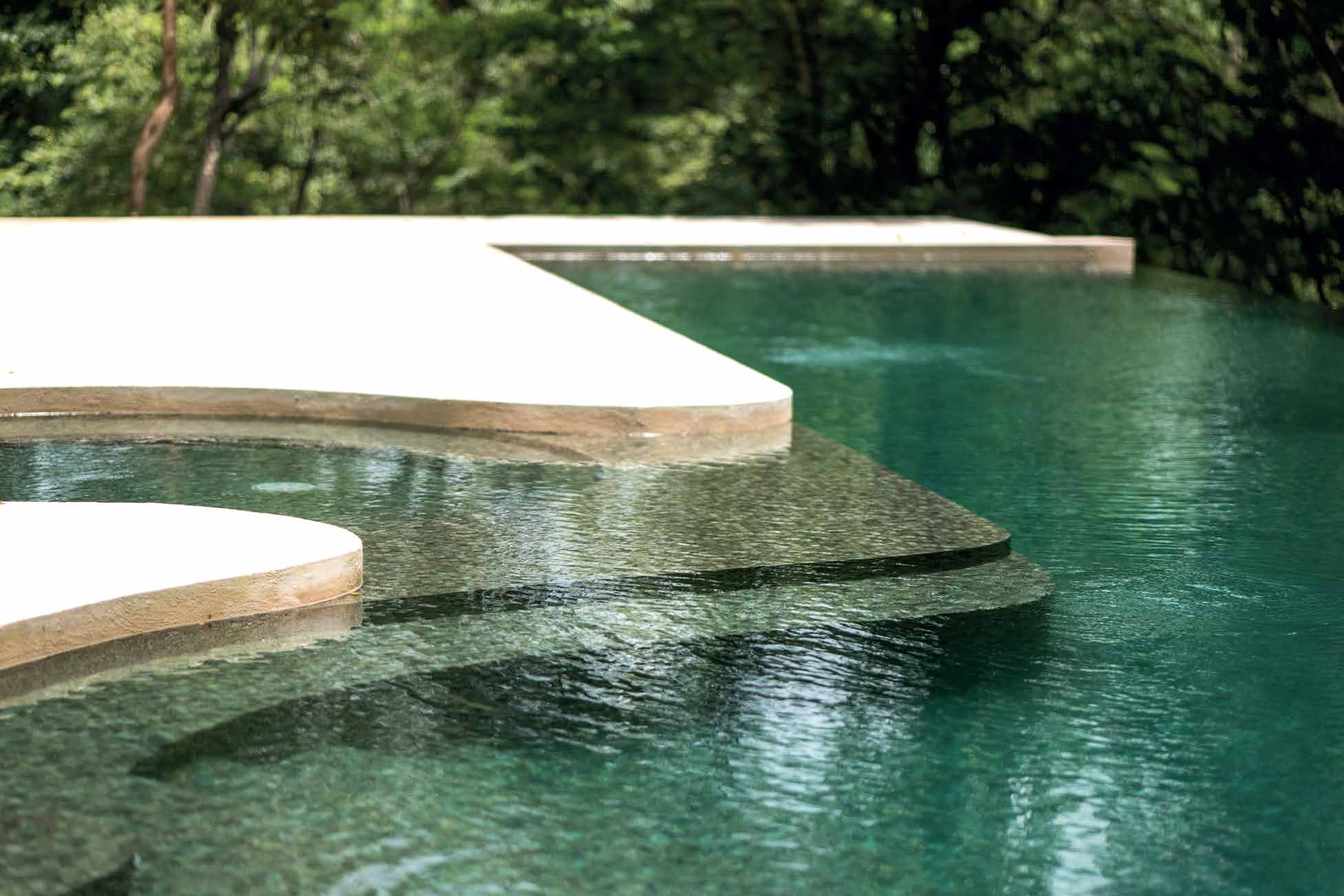 Infinity pool surrounded by jungle at La Ecovilla